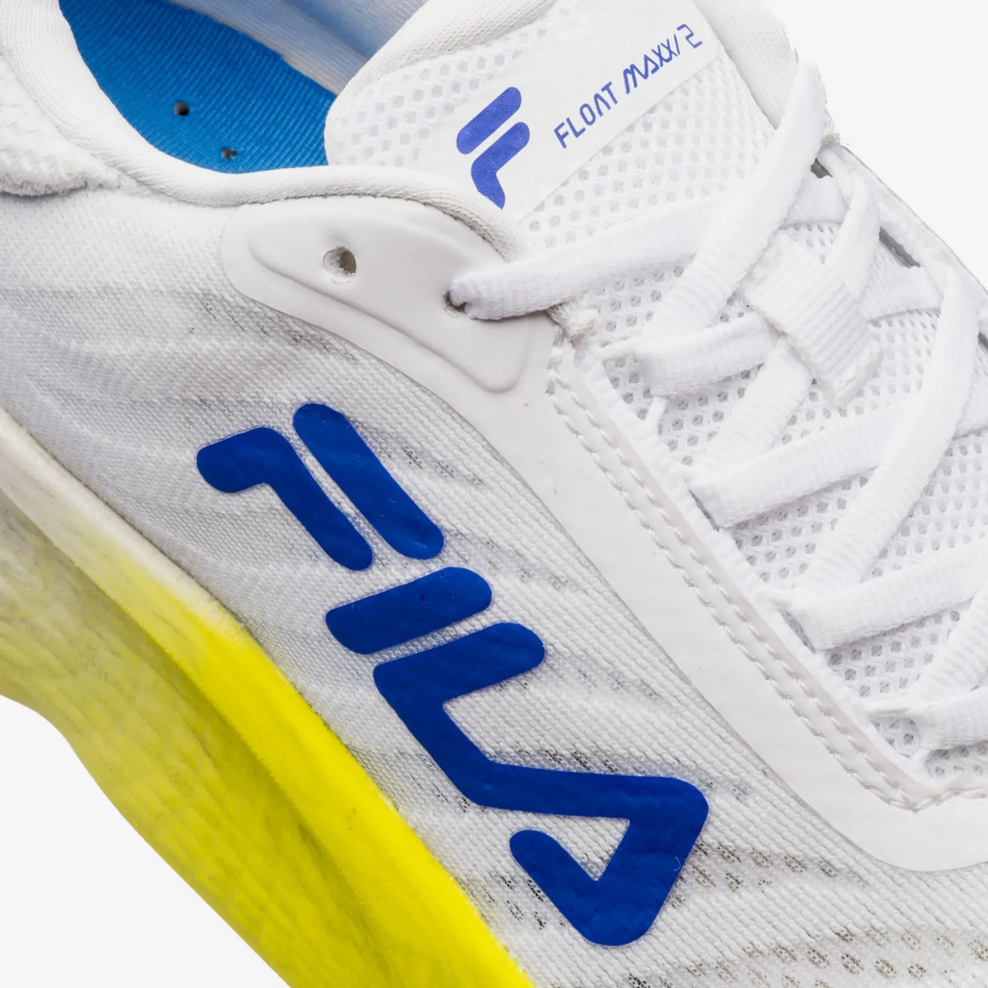 Tênis Fila Float Maxxi 2 branco masculino com detalhes em azul royal e sola amarela em ângulo lateral